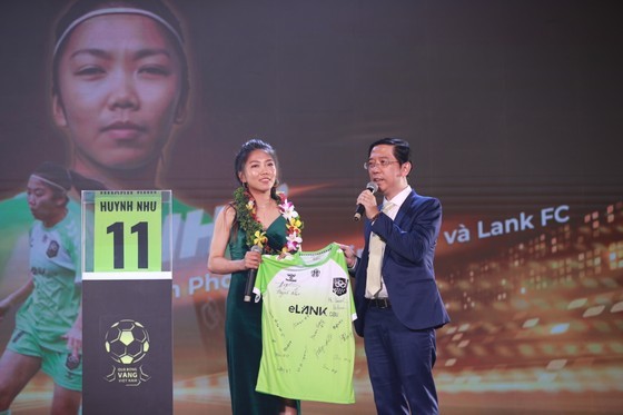 Striker Huynh NHu (L) presents a T-shirt with the signatures of footballers of the Lank FC to the organization board. (Photo: SGGP)