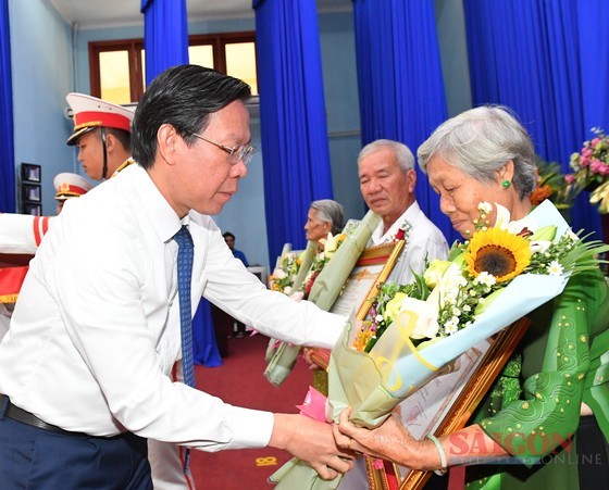Chairman of the HCMC People’s Committee Phan Van Mai presents the "Vietnamese Heroic Mother" title to relatives of mothers. (Photo: SGGP)