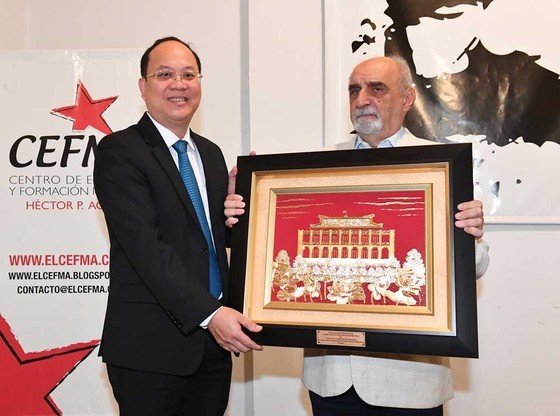 Vice Secretary of the HCMC Party Committee Nguyen Ho Hai (L) hands over Secretary of the HCMC Party Committee Nguyen Van Nen’s present to the Communist Party of Argentina. (Photo: SGGP) Vice Secretary of the HCMC Party Committee Nguyen Ho Hai (L) hands over Secretary of the HCMC Party Committee Nguyen Van Nen’s present to the Communist Party of Argentina. (Photo: SGGP)