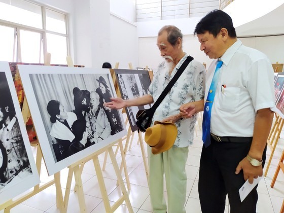People’s Artist Manh Dung (L) sees the photo exhibition at the gathering. (Photo: SGGP)
