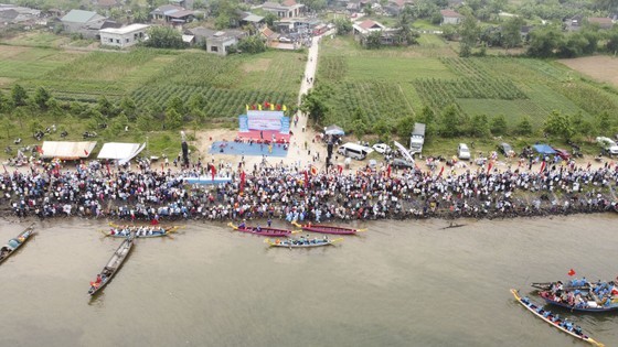 Local people gather on the banks of the river to enjoy the boat race. (Photo: SGGP)