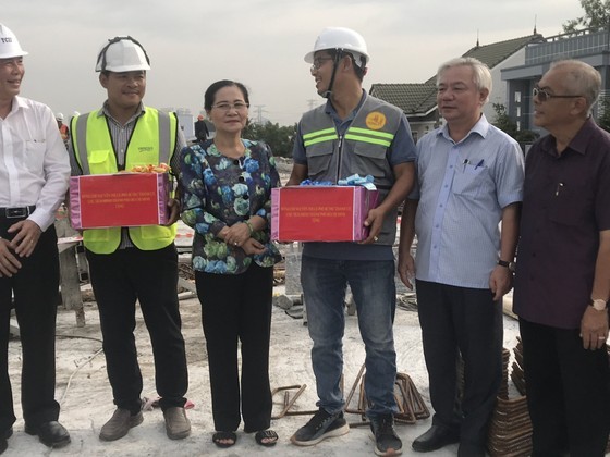 Chairwoman of the HCMC People’s Council Nguyen Thi Le offers gifts to workers on the construction site of the project. (Photo: SGGP) Chairwoman of the HCMC People’s Council Nguyen Thi Le offers gifts to workers on the construction site of the project. (Photo: SGGP)