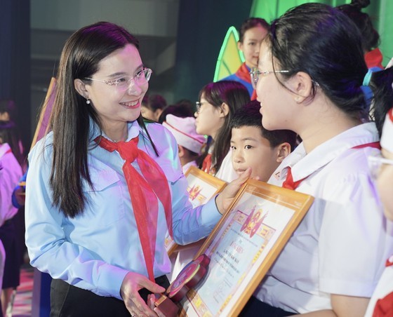 Secretary of the Youth Union Central Committee, Chairwoman of the Ho Chi Minh Young Pioneer Organization&apos;s Central Council Nguyen Pham Duy Trang offers certificates of merit to exemplary children. (Photo: SGGP)