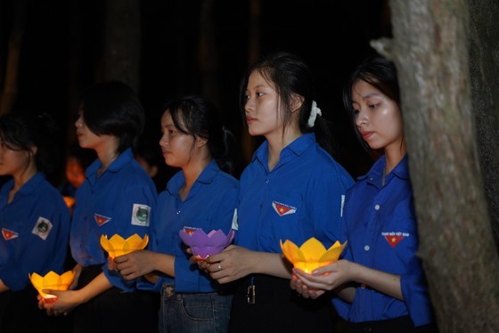 Young volunteers join candle lighting ceremony in commemoration of heroic martyrs in Dong Loc T- Junction historical site. (Photo: SGGP)