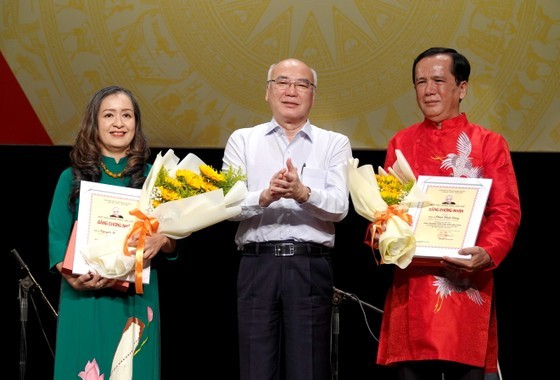 Head of the Propaganda and Education Board of the City Party Committee Phan Nguyen Nhu Khue (C) offer Tran Van Khe Awards to Meritorious Artist Nguyen Thi Hai Phuong, head of the Department of Folk Music of the HCMC Conservatory of Music (L); and MA.Phan Nhut Dung, a folk musician. (Photo: SGGP)