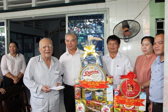 Vice Chairman of the HCMC People’s Committee Ngo Minh Chau offers a gift to wounded soldier Phan Cong Nam. (Photo: SGGP)