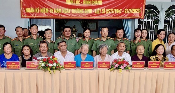 Deputy Director of the HCMC Department of Public Security Le Quang Dao and police officers visit families credited with revolutionary service at the security zone T4 in Vinh Loc A Commune of Binh Chanh District. (Photo: SGGP)