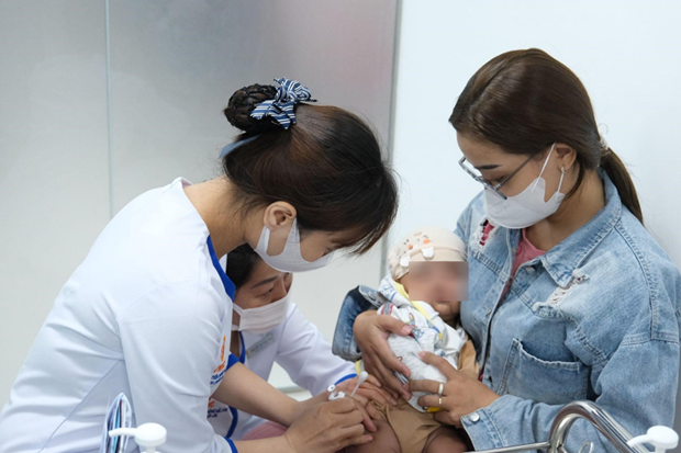 A woman brings her child to get vaccinated at the VNVC vaccination center. (Photo: VNA) A woman brings her child to get vaccinated at the VNVC vaccination center. (Photo: VNA)