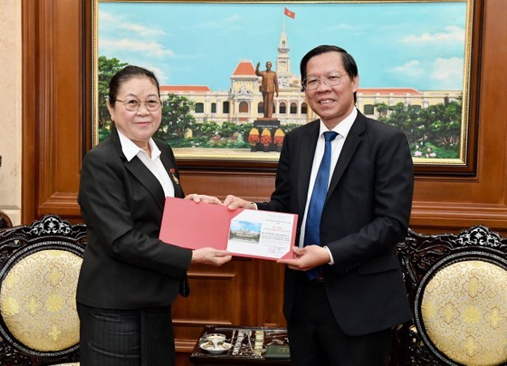 Chairman of the HCMC People’s Committee Phan Van Mai grants the HCMC insignia to Ms. Phimpha Keomixay for her contributions to promoting traditional friendship and cooperation between Vietnam and Laos. (Photo: SGGP)