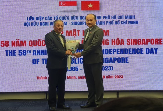 Mr. Roy Kho Ngee Seng, Consul General of Singapore in HCMC (R) offers flowers to Chairman of the HCMC Union of Friendship Organizations (HUFO) Do Viet Ha. (Photo: SGGP) Mr. Roy Kho Ngee Seng, Consul General of Singapore in HCMC (R) offers flowers to Chairman of the HCMC Union of Friendship Organizations (HUFO) Do Viet Ha. (Photo: SGGP)