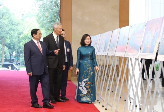 Prime Minister Pham Minh Chinh and Singaporean Prime Minister Lee Hsien Loong visit a photo exhibition on Vietnam-Singaporea relationships. (Photo: SGGP)