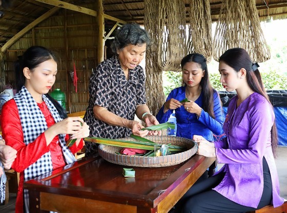 Visitors lean about making traditional cakes in Con Son Tourist Area in Can Tho City. (Photo: SGGP)