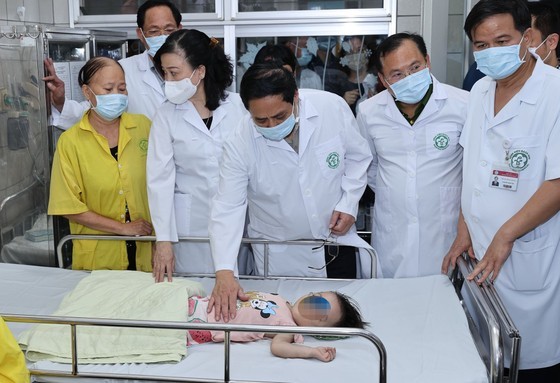 The PM visits persons who were injured at fires and were being treated at Bach Mai Hospital. (Photo: SGGP)