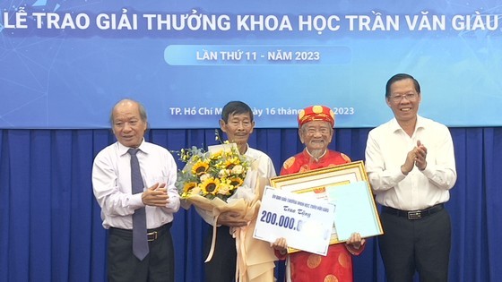 Chairman of the HCMC People’s Committee Phan Van Mai (R) and a representative of the Committee of the Tran Van Giau Science Awards offer the prize to researcher Nguyen Dinh Tu (C). (Photo: SGGP) Chairman of the HCMC People’s Committee Phan Van Mai (R) and a representative of the Committee of the Tran Van Giau Science Awards offer the prize to researcher Nguyen Dinh Tu (C). (Photo: SGGP)