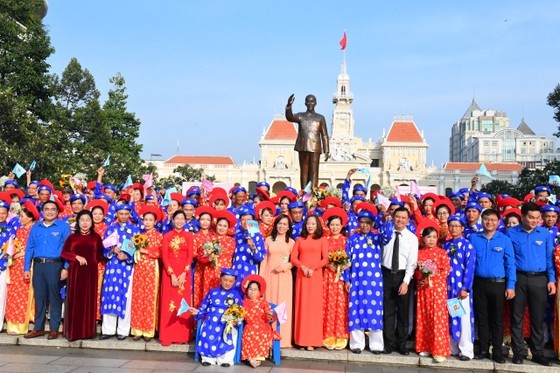 The couples offer flowers to President Ho Chi Minh at his statue at Ho Chi Minh Statue Park in front of the City Hall. (Photo: SGGP)