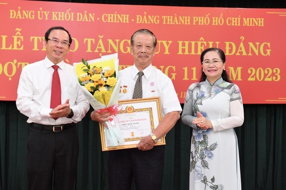 Secretary of the HCMC Party Committee Nguyen Van Nen (L) and Chairwoman of the HCMC People’s Council Nguyen Thi Le (R) offer the 55-year Party membership badge to Party member Trieu Quoc Manh. (Photo: SGGP) Secretary of the HCMC Party Committee Nguyen Van Nen (L) and Chairwoman of the HCMC People’s Council Nguyen Thi Le (R) offer the 55-year Party membership badge to Party member Trieu Quoc Manh. (Photo: SGGP)
