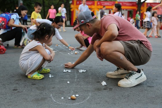 Kids and their parents play the traditional Vietnamese folk game, O An Quan. (Photo: SGGP)