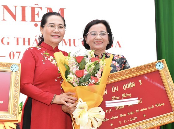 Chairwoman of the HCMC People’s Council Nguyen Thi Le (L) presents a Party membership badge to former Head of the Propaganda and Education Board of the HCMC Party Committee Than Thi Thu