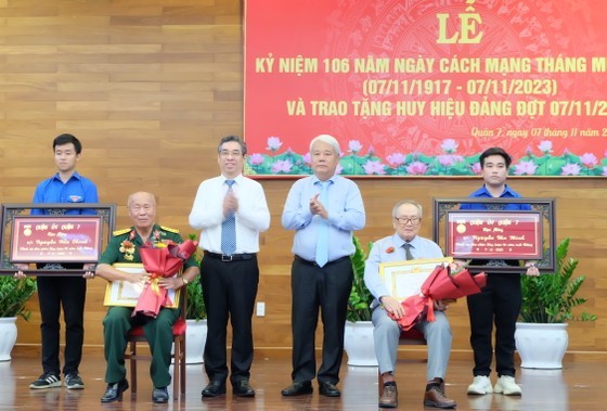 Vice Secretary of the HCMC Party Committee Nguyen Phuoc Loc congratulates Party members receiving Party membership badges in District 7.
