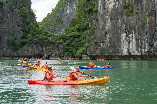 Tourists kayaking across a vast body of water in Ha Long Bay (Photo: VNA)