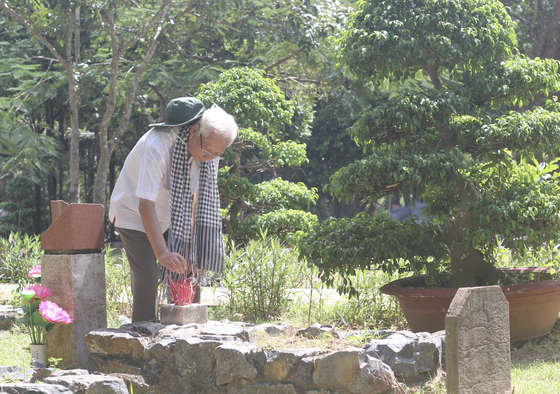Screenwriter Cao Huu Tuong, a former Con Dao prisoner, offers incense to martyrs. (Photo: SGGP)