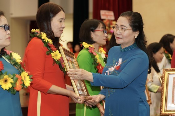 Chairwoman of the HCMC People’s Council Nguyen Thi Le offers certificatse of merit to teachers. (Photo: SGGP)