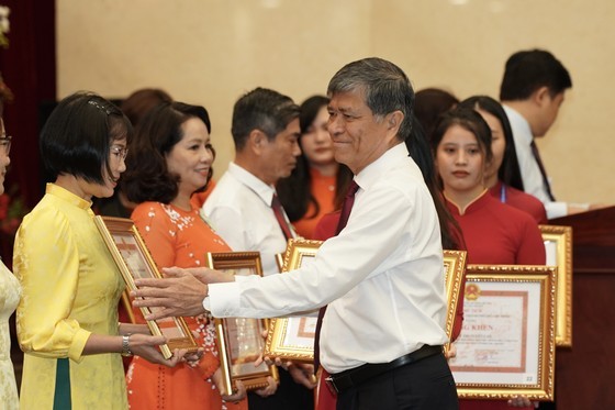Mr. Nguyen Van Hieu, Director of the city Department of Education and Training presents the Vo Truong Toan Awards to teachers. (Photo: SGGP)