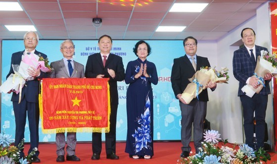 Vice Chairman of the HCMC People’s Committee Duong Anh Duc (3rd, L) presents the Flag of Tradition to Nguyen Tri Phuong Hospital. (Photo: SGGP) Vice Chairman of the HCMC People’s Committee Duong Anh Duc (3rd, L) presents the Flag of Tradition to Nguyen Tri Phuong Hospital. (Photo: SGGP)