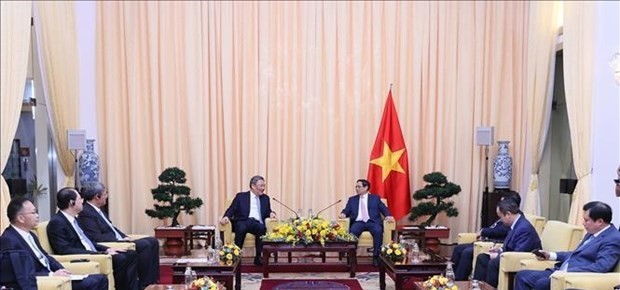 Prime Minister Pham Minh Chinh (R) receives Chinese Minister of Commerce Wang Wentao. (Photo: VNA)