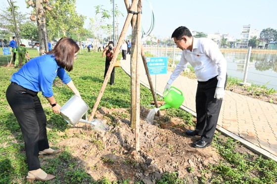 Chairman of the Inspection Commission of the HCMC Party Committee Duong Ngoc Hai (R) and youths water trees in the park. (Photo: SGGP) Chairman of the Inspection Commission of the HCMC Party Committee Duong Ngoc Hai (R) and youths water trees in the park. (Photo: SGGP)