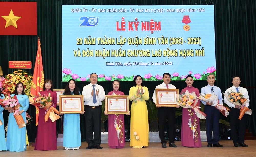 Former Secretary of the HCMC Party Committee Nguyen Thien Nhan (4th,L) and Deputy Minister of Industry and Trade Phan Thi Thang (5th, R) give the second-class Labor Medal to collectives. (Photo: SGGP) img-4963da91ae03ae1dce0a3100be8bfc6a-v-6320jpg-4722.jpg