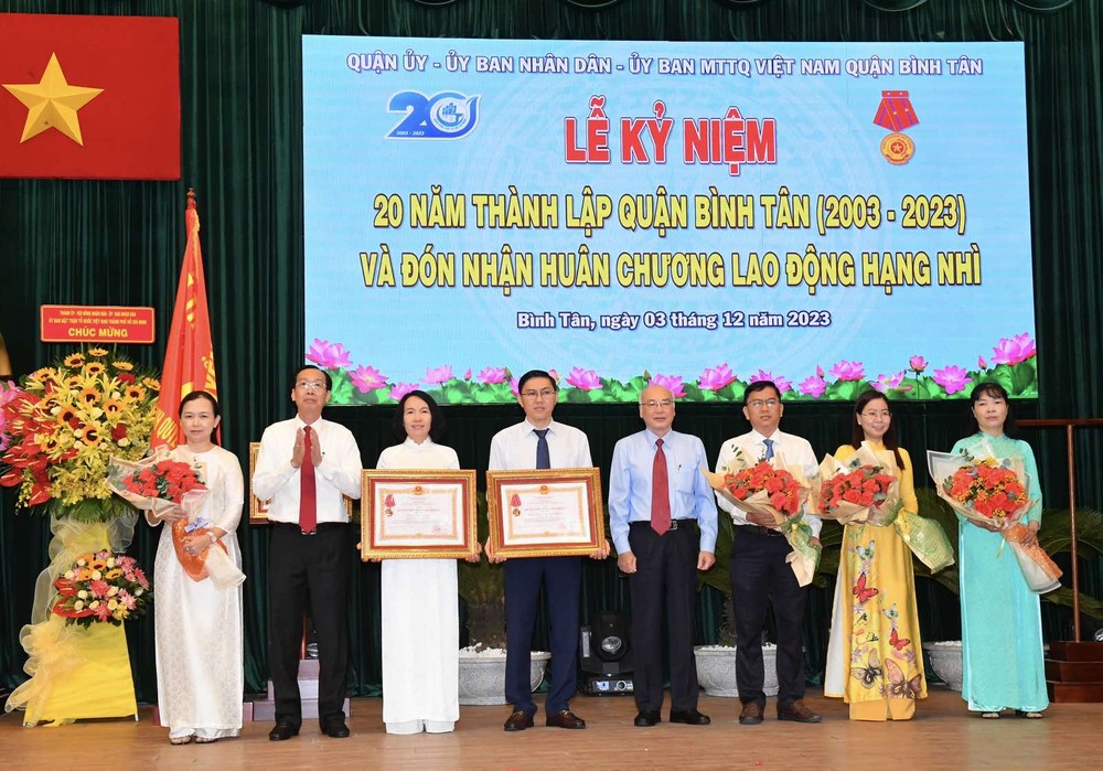 Head of the Propaganda and Education Board of the HCMC Party Committee Phan Nguyen Nhu Khue (4th, R) and Head of the Internal Affairs Committee of HCMC Party Committee Le Thanh Liem (2nd, L) offer the third-class Labor Medals to collectives. (Photo: SGGP) img-a0515947373ad5e8e0059272deb45e9e-v-3382jpg-749.jpg
