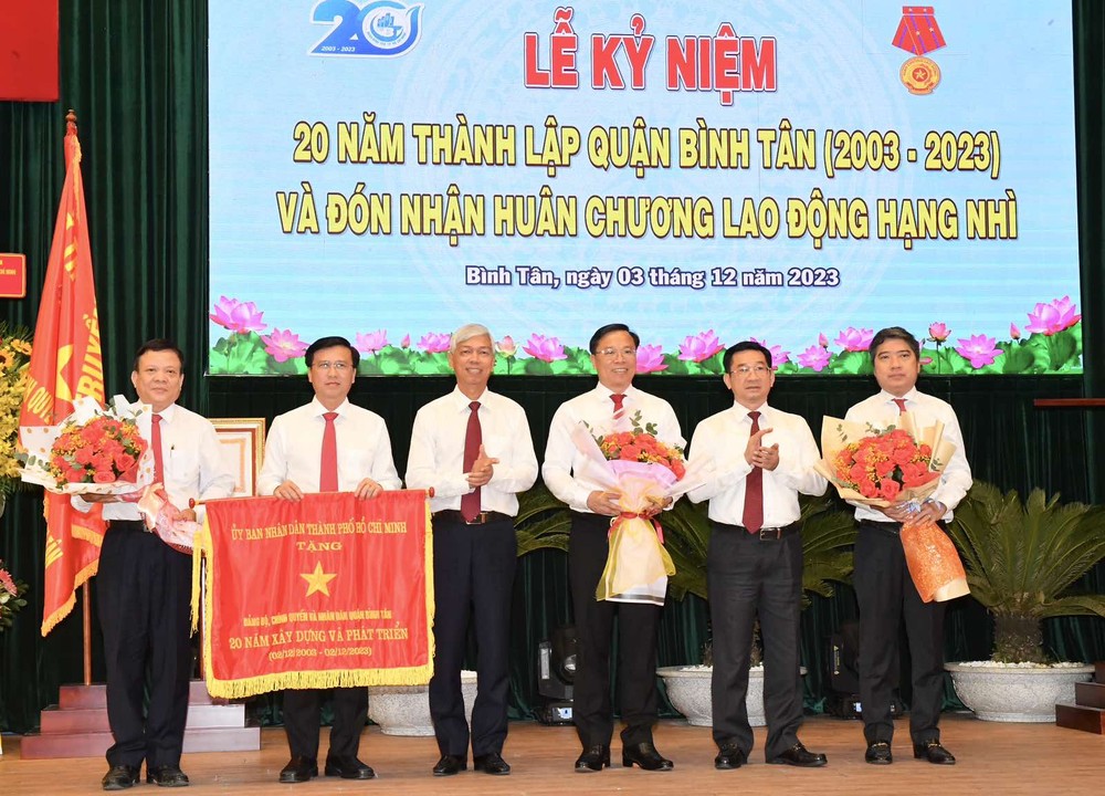 Head of the Inspection Commission of the HCMC Party Committee, Duong Ngoc Hai (2nd,R) and Vice Chairman of the HCMC People's Committee Vo Van Hoan (3rd,L) present the Flag of Tradition to the Party, government, and people of Binh Tan District. (Photo: SGGP) img-cc81376a9364e82a99d900a3bdc50eee-v-1388jpg-418.jpg