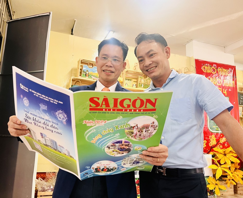 Deputy Head of the Propaganda and Education Board of the Party Committee of Lam Dong Province Tran Trung Hieu (L) visits Sai Gon Giai Phong Newspaper's booth. (Photo: SGGP) ea06903079bed3e08aaf-5557jpg-896.jpg