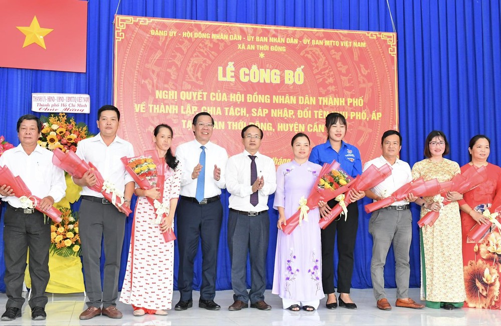 Chairman of the HCMC People's Committee Phan Van Mai (4th, L) and Secretary of the Party Committee of Can Gio District Nguyen Phuoc Hung (5th, L) offer flowers to cadres of new administrative units. (Photo: SGGP) img-85c5e407749e161493f75e17daa6d314-v-4425.jpg.jpg