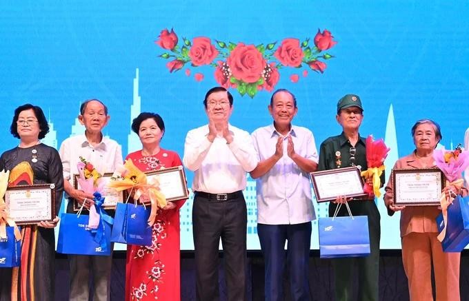 Former State President Truong Tan Sang (4th, L) and former Standing Deputy Prime Minister Truong Hoa Binh (3rd, R) offer gifts to former political prisoners and prisoners of war. cuutu.jpg