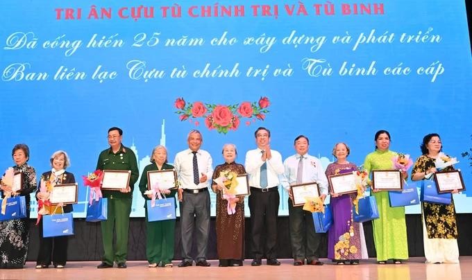 Vice Secretary of the Ho Chi Minh City Party Committee cum Chairman of the Vietnam Fatherland Front Committee of the city Nguyen Phuoc Loc (5th, R) offers gifts to former political prisoners and prisoners of war. cuutu2.jpg