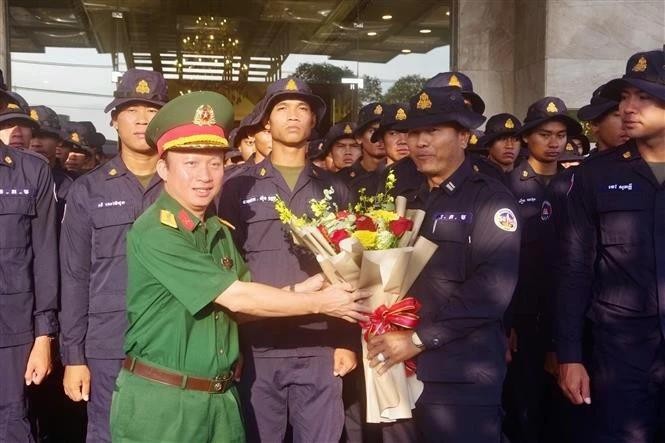 Colonel Nguyen Dinh Chuan, Political Commissar of the Binh Duong provincial Military Command (left), presents flowers to the Cambodian delegation. (Photo: VNA) vna-potal-binh-duong-tien-cac-doan-quan-doi-quoc-te-ve-nuoc-sau-le-dieu-binh-dieu-hanh-8007678.jpg