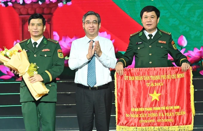Vice Secretary of the Ho Chi Minh City Party Committee Nguyen Phuoc Loc (C) offers the Traditional Flag to the Ho Chi Minh City Border Guard Command on May 7. (Photo: SGGP) z6576795156787-10d6f921ad249cce3fac4582cc3dac3d-7235-1421.jpg