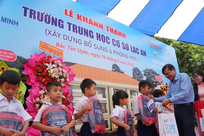 Deputy Head of the Propaganda and Mass Mobilization Commission of the Ho Chi Minh City Party Committee Tang Huu Phong offers gifts to students. (Photo: SGGP) a8-1-2495-4876.jpg