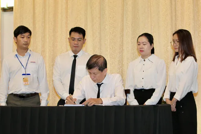 Journalist Nguyen Khac Van, Deputy Editor-in-Chief in charge of Sai Gon Giai Phong Newspaper writes the condolence book. (Photo: SGGP) 14-8156-3919.jpg