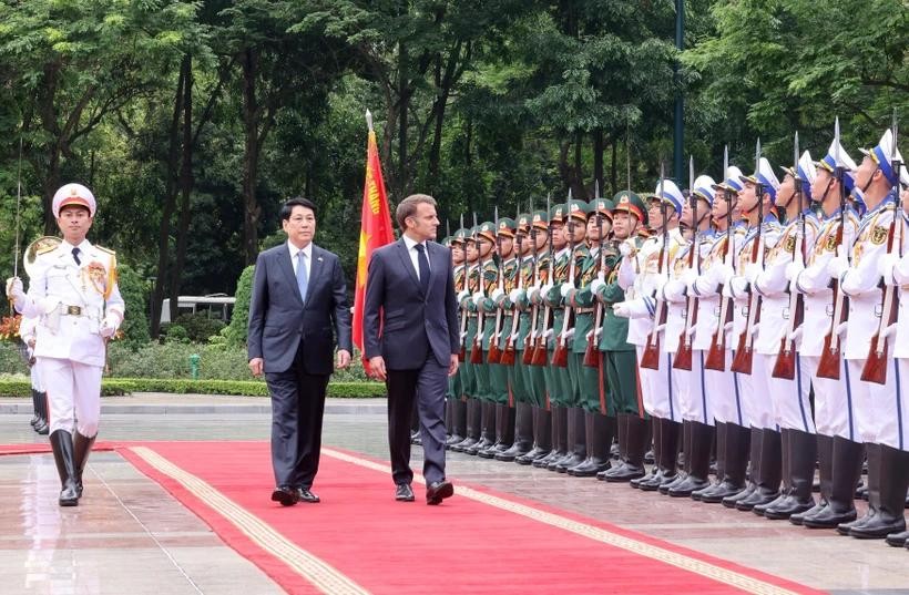 State President Luong Cuong (left) and French President Emmanuel Macron review the Guard of Honour of the Vietnam People’s Army. (Photo: VNA) je.jpg