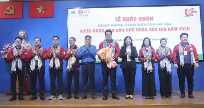 Deputy Head of the Propaganda and Mass Mobilization Commission of the the Ho Chi Minh City Party Committee, Nguyen Thi Bach Mai (4th, R) and Secretary of the Ho Chi Minh City Youth Union cum Chairman of the Vietnam Youth Federation in the city, Ngo Minh Hai (5th, L) offer flowers to volunteers. (Photo: SGGP) z6691579788990-90739a3a6671497b9c5cdf7c9f55263a-9783-3734.jpg