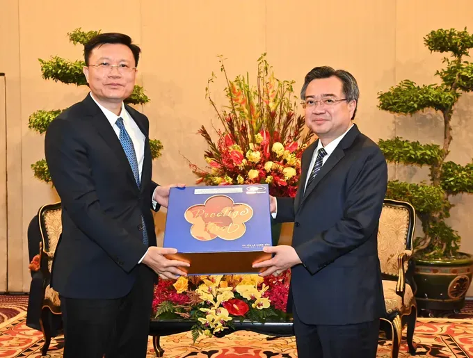 Standing Vice Secretary of the HCMC Party Committee, Nguyen Thanh Nghi, offers a gift to Vice Secretary of the Party Committee of China’s Guangzhou City, Chen Xiāngtán. (Photo: SGGP) z6763923478878-0d2fadba3177140accf1e51f426c3035-2684-182.jpg