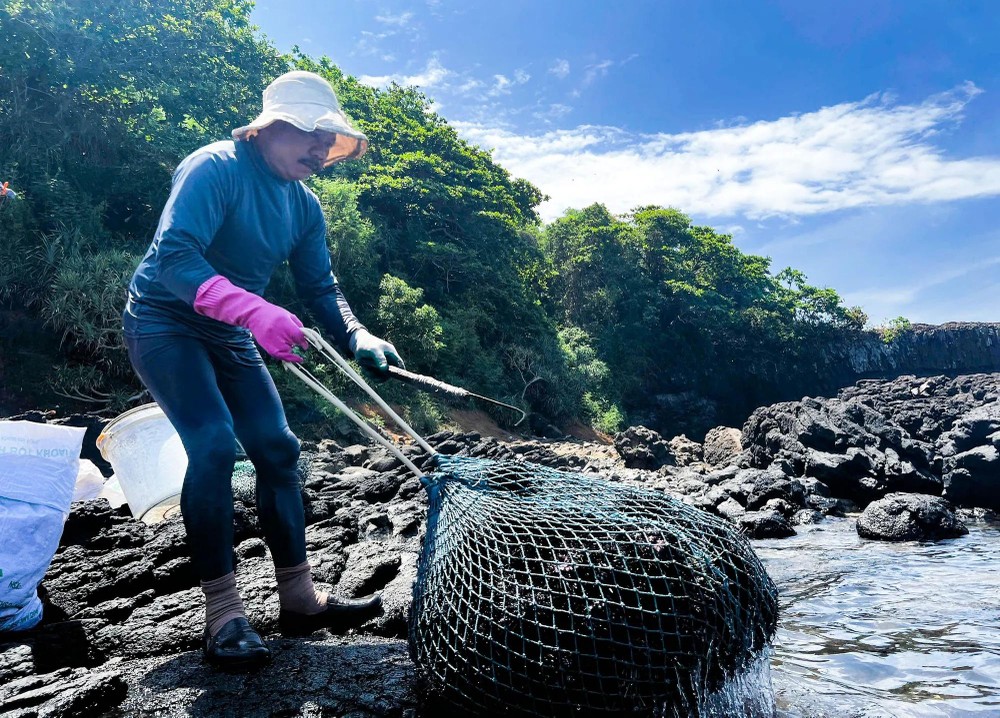 Fisherman Nguyen Van Dao pulls the sea urchin nets onto the rocky reefs. 16.jpg