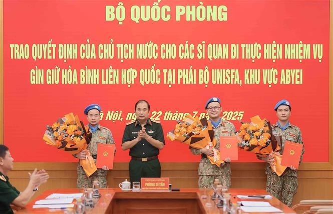 Senior Lieutenant General Phung Si Tan (second from left), Deputy Chief of the General Staff, presents decisions of the State President and the Minister of National Defence to three officers who are about to depart for duties at the UN peacekeeping mission in Abyei. (Photo: VNA) un-peacekeepers-vietnam-vna.jpg