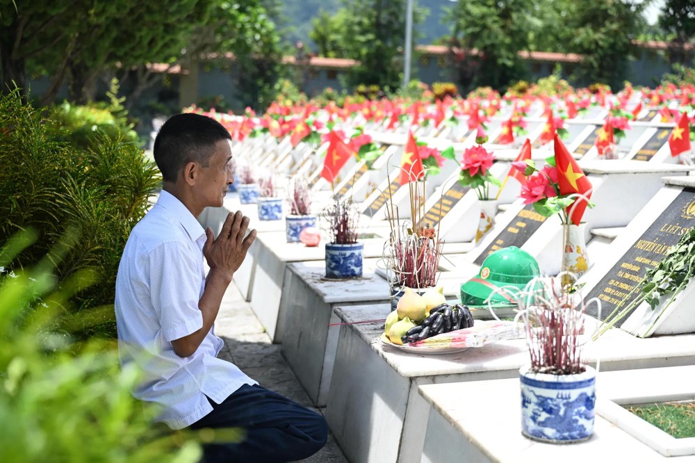 Mr. Nguyen Duc Hien, and his family, traveled to Vi Xuyen National Martyrs’ Cemetery to offer incense in memory of his elder brother, martyr Nguyen Van Thanh. (Photo: SGGP) 8.jpg