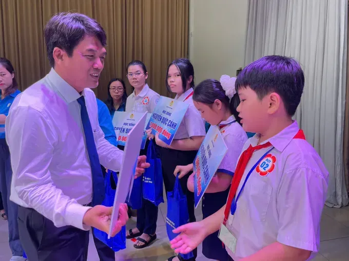 President of the Ho Chi Minh City Labor Federation, Bui Thanh Nhan, presents scholarships to stduents. (Photo: SGGP) z6845893506551-43bd49c0a5f2fed0b20c9806f785e5d9-6730-1079.jpg