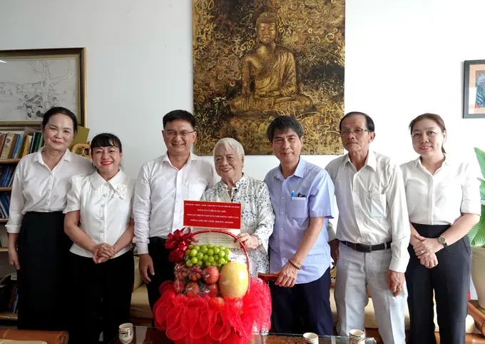 Head of the Propaganda and Mass Mobilization Commission of the Ho Chi Minh City Party Committee Nguyen Manh Cuong (3rd, L) and the city's officials visit writer Xuan Phuong (4th, R). (Photo: SGGP) dsc00156-7300-9941.jpg