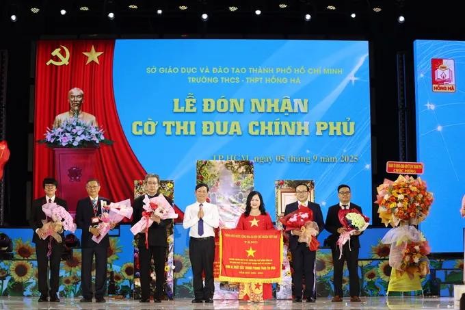 Chairman of the Ho Chi Minh City People’s Council, Vo Van Minh (4th, L) offers the Second-class Labor Order and the Government’s Emulation Flag to Hong Ha Secondary and High School. 10.jpg